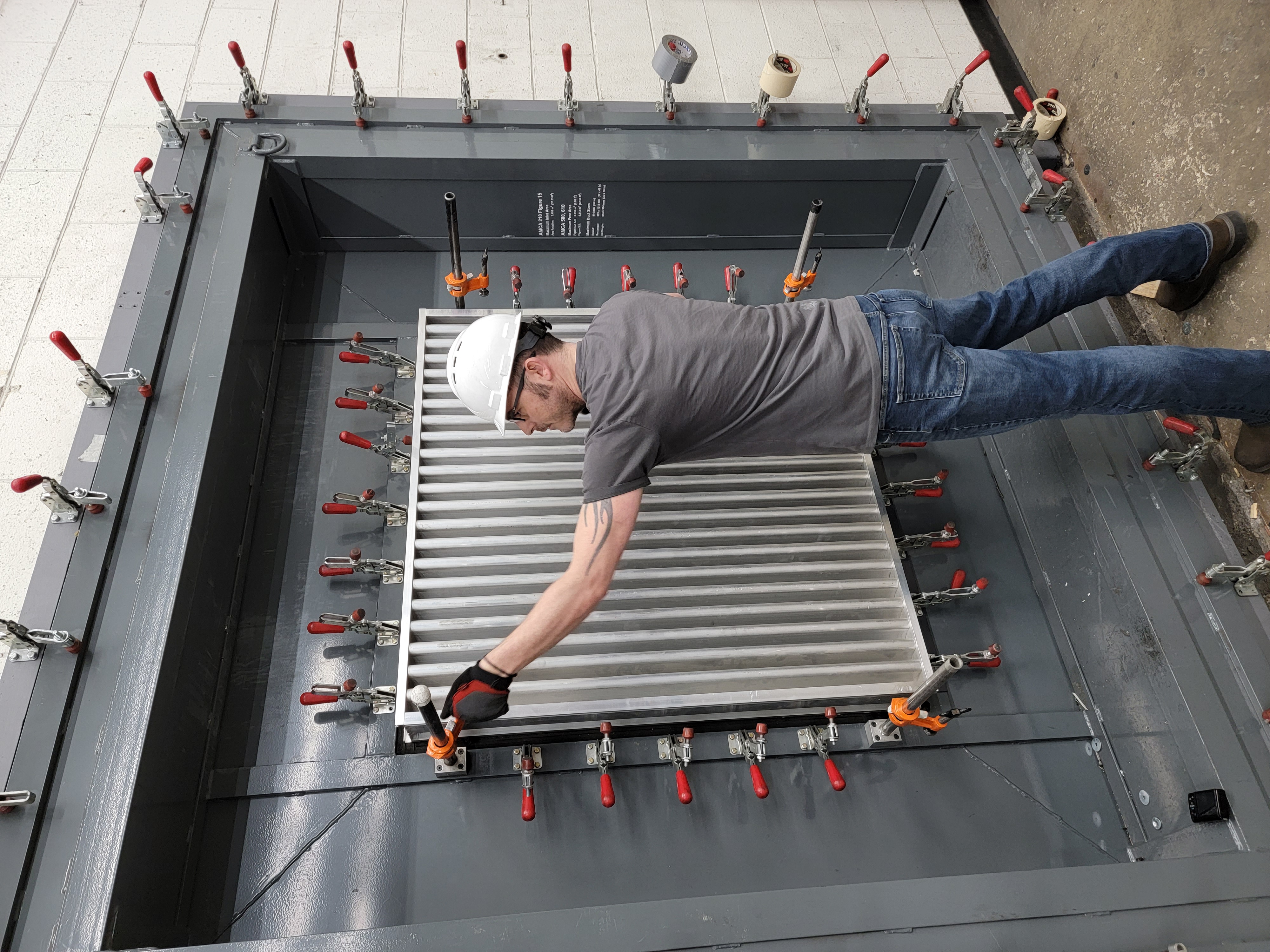 AMCA Laboratory Technician Jordan Boyer prepares a louver for an ANSI/AMCA Standard 500-L, Laboratory Methods of Testing Louvers for Rating, Figure 5.5 pressure-drop test.